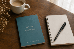 A copy of A Gentle Reminder by Bianca Sparacino placed beside a notebook and coffee on a wooden table near soft natural light.